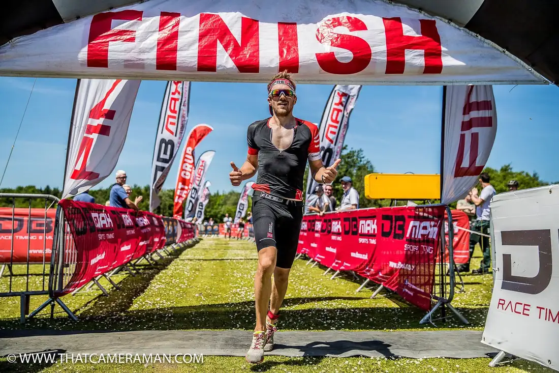 Tom Cooling running through the finish arch to complete the Brecon Titan