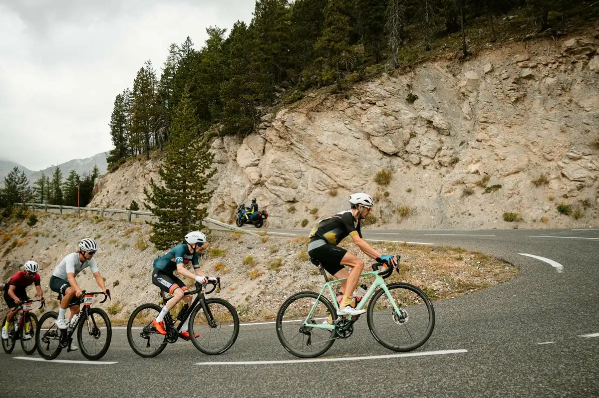 Sportive riders rounding an alpine hairpin towards the camera
