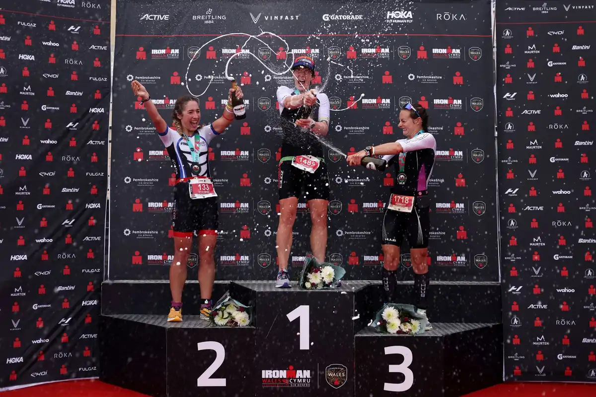 The women's podium celebration at Ironman Wales with champagne mid-spray