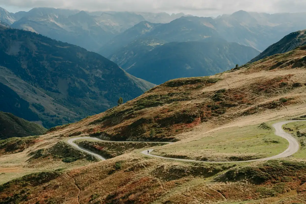 A lone cyclist on a switchback gravel road high in the Pyrenees